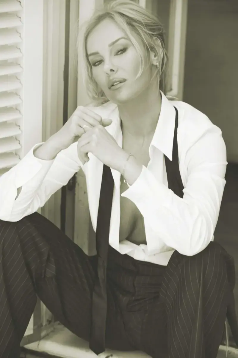 Black-and-white portrait of Katherine Taylor seated in a white shirt and suspenders, hands clasped near her chin